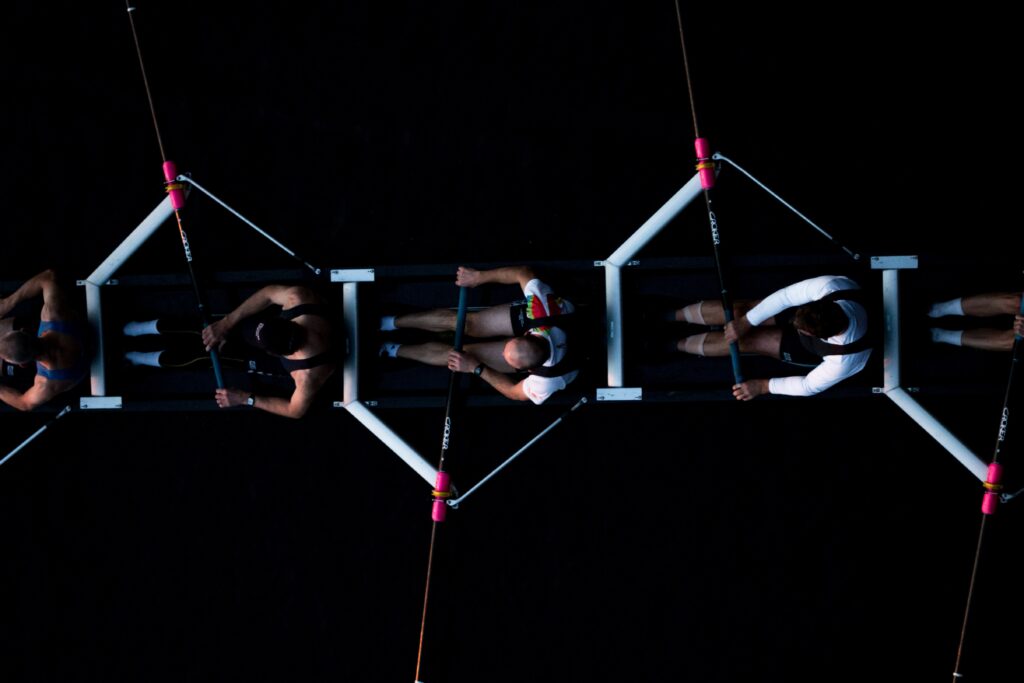 Overhead view of a rowing team working in sync, symbolising high-performing A Players driving growth together.